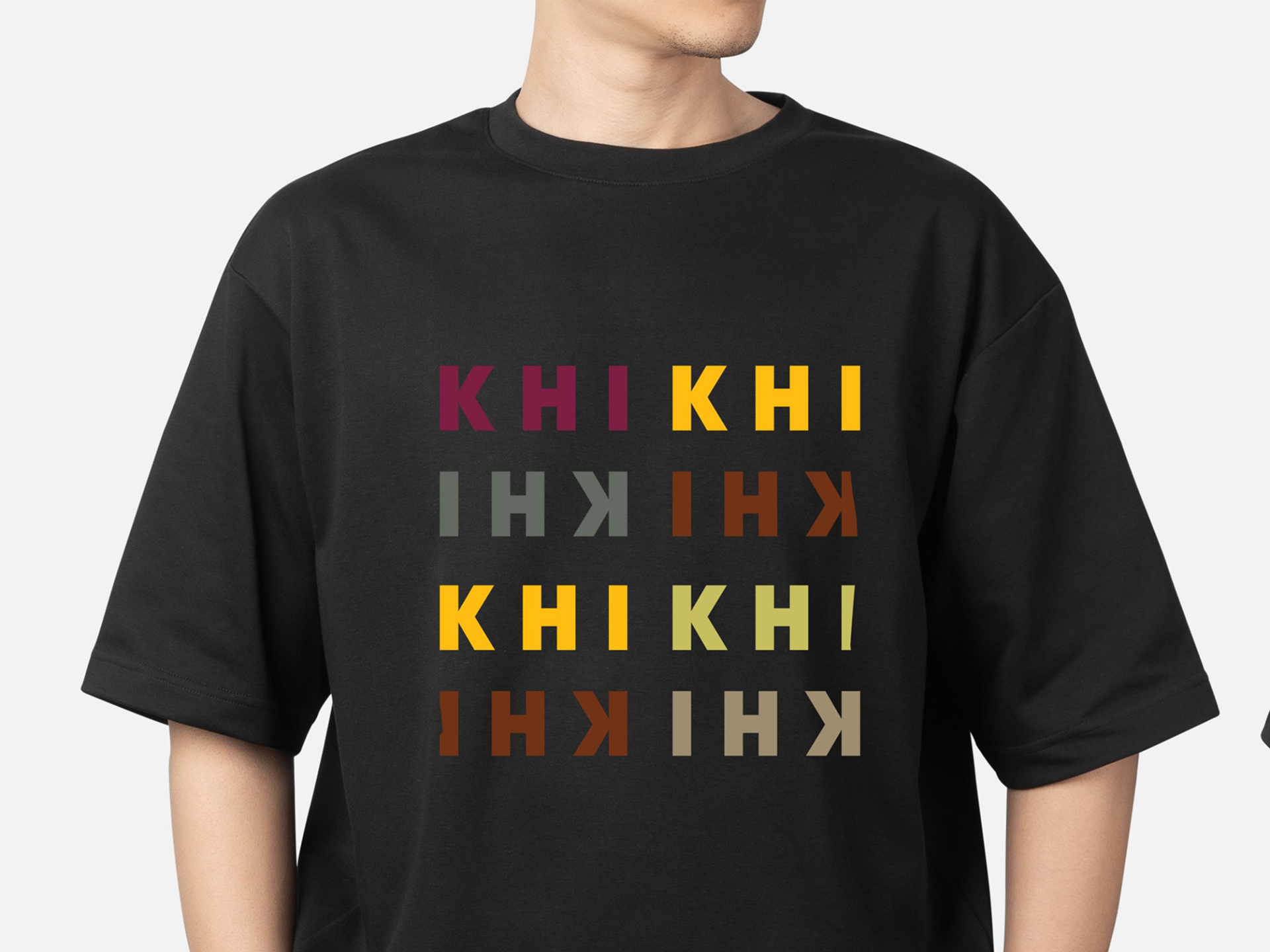 KHI KHI branded black t-shirt featuring multicolored logo variations in burgundy, yellow, olive, and brown tones